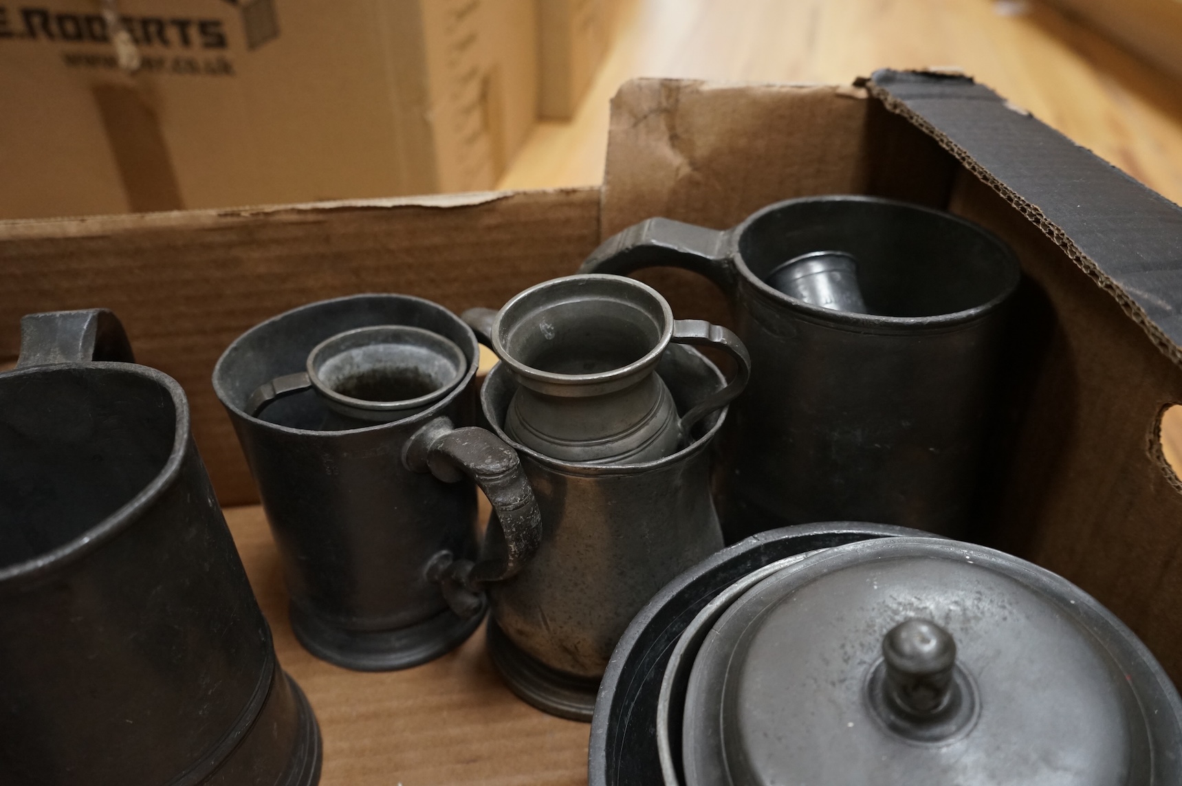 A quantity of pewter to include tankards, dishes and a pair of candlesticks